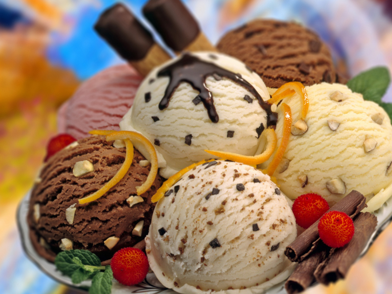 A composition of various flavours ice cream balls decorated with red fruits,chocolate curls and mint