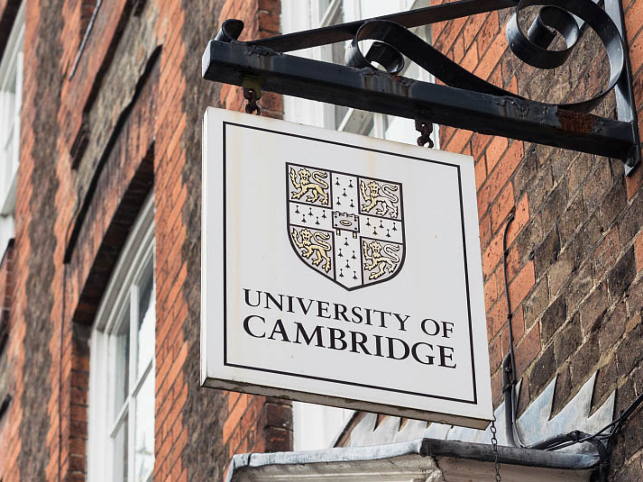 Cambridge, UK - A University of Cambridge  sign above the entrance to a Victorian building in the centre of the traditional English university city.